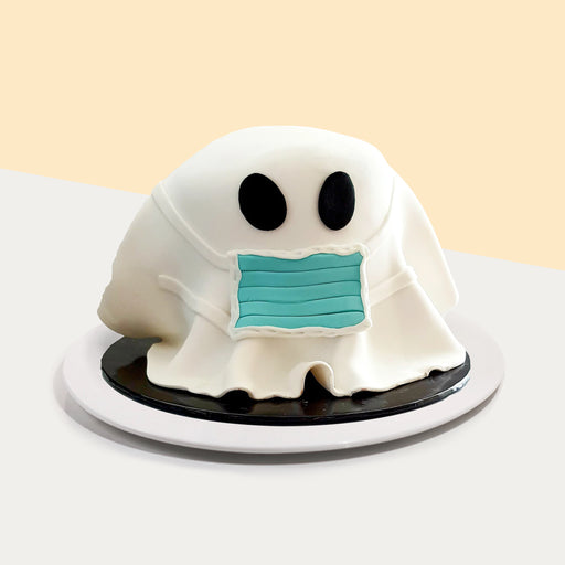 Cake decorated to look like a ghost wearing a face mask
