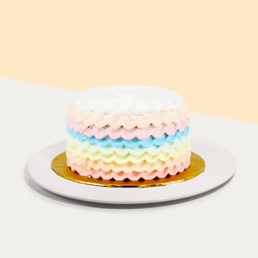 Rainbow sponge cake decorated with rainbow cream ruffles