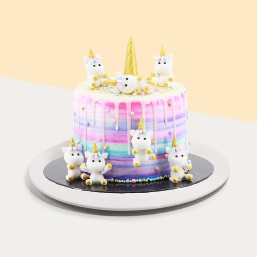 Rainbow cake with mini unicorns made of fondant