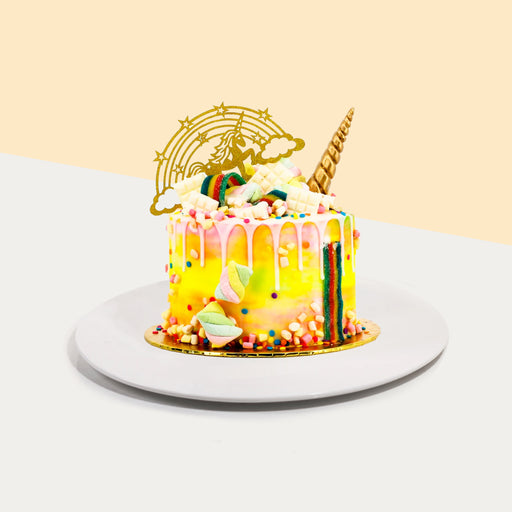 Yellow buttercream unicorn themed cake topped with candies