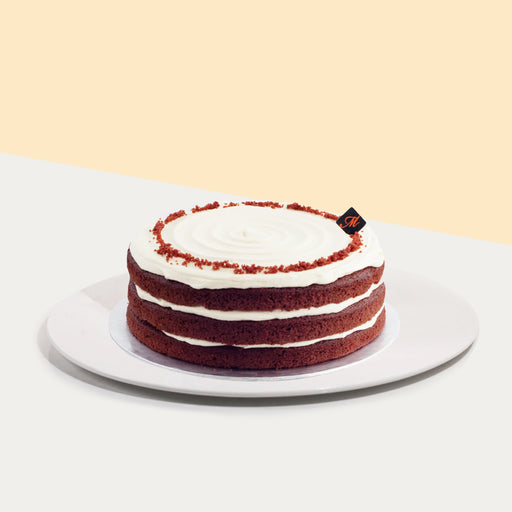 Chocolate cake with red hue, layered with cream cheese frosting