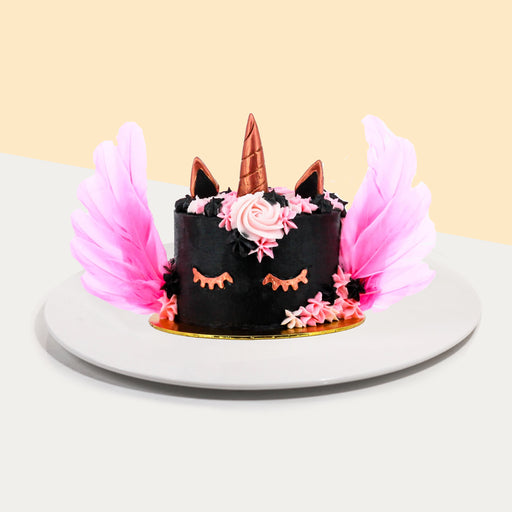 Black unicorn cake with rose gold decorations, with pink feathered wings