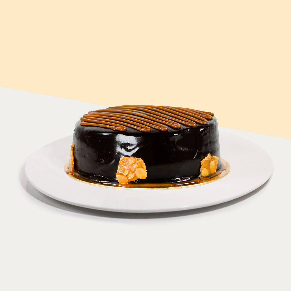 Salted Caramel Chocolate Cake coated in chocolate ganache, topped with caramel sauce