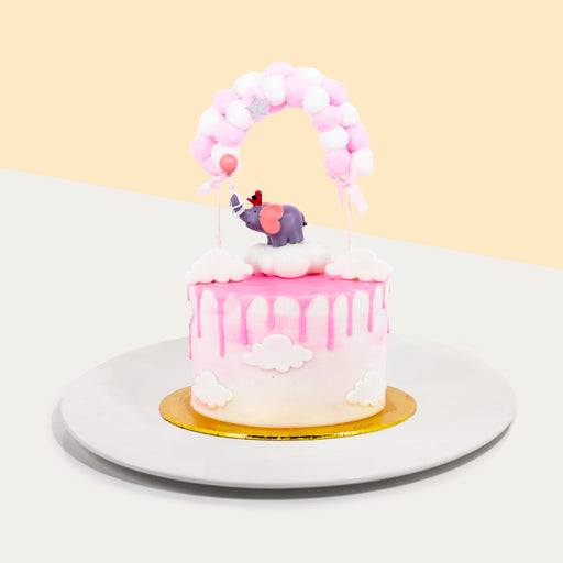Baby girl themed cake in pink, with baby elephant figurine on top
