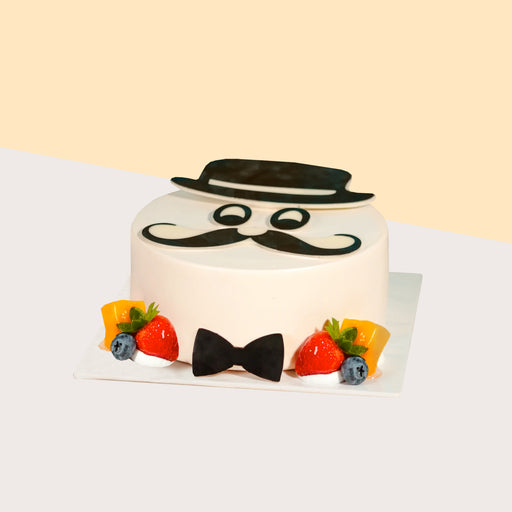 Vanilla chiffon cake with mango layers, decorated with edible bowtie, moustache and hat