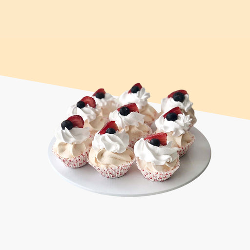 Sixteen pieces of pavlova bites, topped with fresh cream, strawberries and blueberries